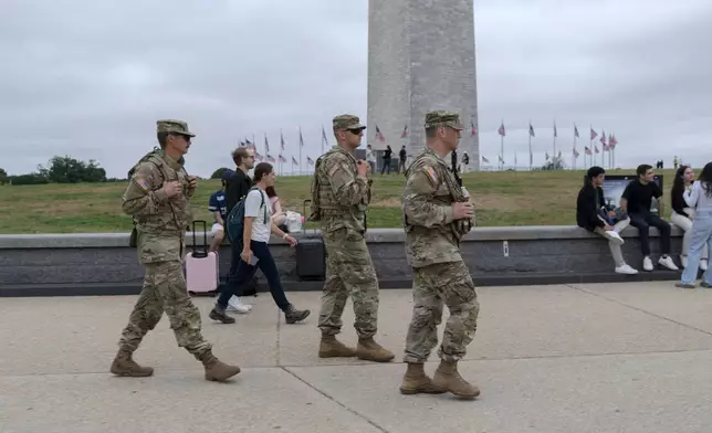 Members of the District of Columbia National Guard patrol near the Washington Monument on the National Mall, Tuesday, Aug. 19, 2025, in Washington. (AP Photo/Jose Luis Magana)