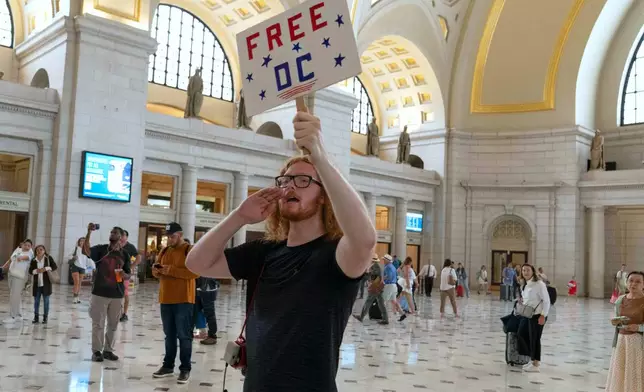 A demonstrator yells at Vice President JD Vance, Defense Secretary Pete Hegseth and White House Deputy Chief of Staff Stephen Miller as they meet with members of the National Guard at Union Station, in Washington Wednesday. Aug. 20, 2025. (AP Photo/Jose Luis Magana)