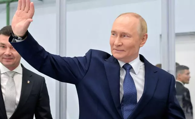 Russian Prime Minister Vladimir Putin waves while visiting the Omega Sea plant in Magadan, about 6,000 kilometers (3,700 miles) east of Moscow, Russia's Far East, on Friday, Aug. 15, 2025, on the way to Alaska. (Alexei Nikolsky, Sputnik, Kremlin Pool Photo via AP)