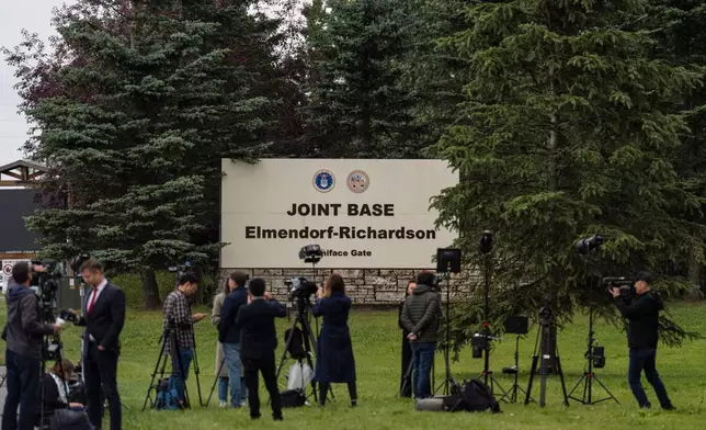 Members of the media stand outside Joint Base Elmendorf-Richardson in Anchorage, Alaska, Thursday, Aug. 14, 2025, ahead of a meeting between President Donald Trump and Russia's President Vladimir Putin. (AP Photo/Jae C. Hong)
