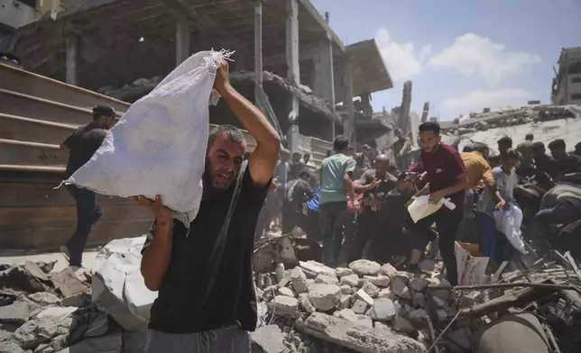 Palestinians struggle to collect humanitarian aid airdropped by parachutes into Gaza City, northern Gaza Strip, Thursday, Aug. 7, 2025. (AP Photo/Jehad Alshrafi)