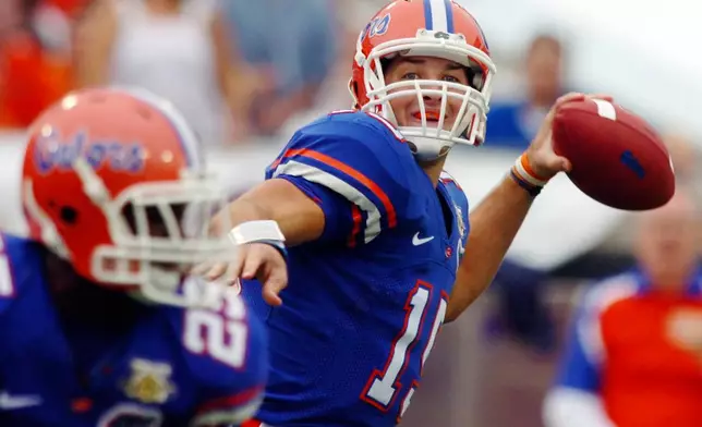 FILE - Florida quarterback Tim Tebow throws a touchdown pass to receiver Louis Murphy during the first quarter of an NCAA college football game against Georgia on Oct. 27, 2007, in Jacksonville, Fla. (AP Photo/Stephen Morton, File)