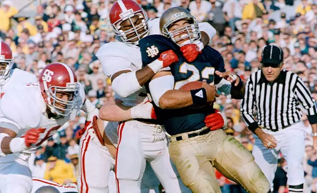 FILE - Notre Dame's Anthony Johnson (22) is stopped by Alabama's Derrick Thomas during the first quarter of an NCAA college football game in South Bend, Ind., Nov. 14, 1987. (AP Photo/Tom Strattman, File)