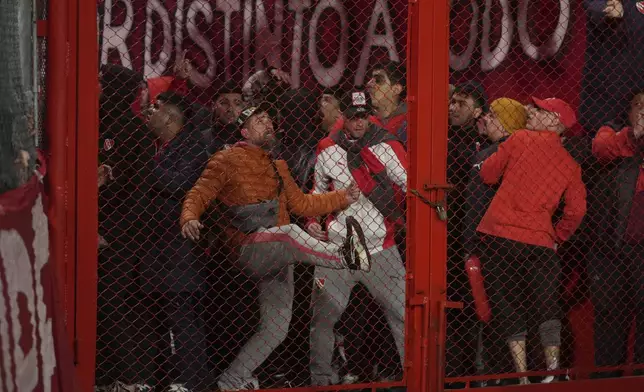Fans of Argentina's Independiente bang on a barrier during a Copa Sudamericana round of sixteen second leg soccer match against Universidad de Chile at the Libertadores de America stadium in Avellaneda, Argentina, Wednesday, Aug. 20, 2025. (AP Photo/Gustavo Garello)