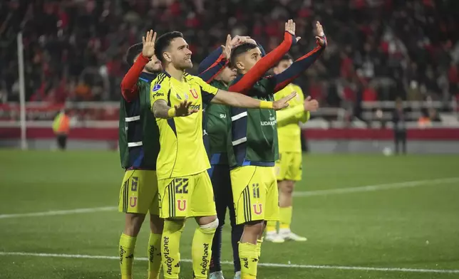Players of Universidad de Chile try to calm down their fans during a Copa Sudamericana round of sixteen second leg soccer match against Argentina's Independiente at the Libertadores de America stadium in Avellaneda, Argentina, Wednesday, Aug. 20, 2025. (AP Photo/Gustavo Garello)