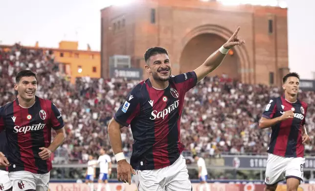 Bologna's Riccardo Orsolini, center, celebrates after scoring the opening goal during the Serie A soccer match between FC Bologna and Como 1907 in Bologna, Italy, Saturday, Aug. 30, 2025. (Massimo Paolone/LaPresse via AP)
