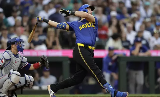 Seattle Mariners' Cal Raleigh hits a solo home run off Texas Rangers starting pitcher Kumar Rocker during the fifth inning in a baseball game Thursday, July 31, 2025, in Seattle. (AP Photo/John Froschauer)