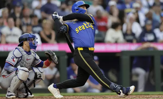 Seattle Mariners' Cole Young hits a solo home run off Texas Rangers starting pitcher Kumar Rocker during the fifth inning in a baseball game Thursday, July 31, 2025, in Seattle. (AP Photo/John Froschauer)