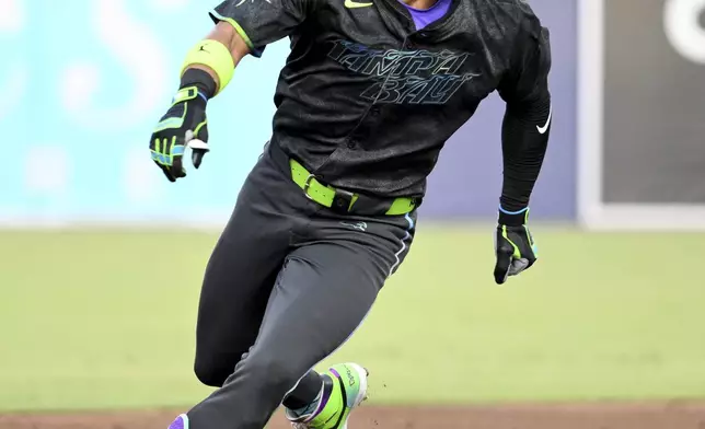 Tampa Bay Rays' José Caballero (77) runs to third base on a Chicago White Sox error after his single during the second inning of a baseball game Tuesday, July 22, 2025, in Tampa, Fla. (AP Photo/Jason Behnken)