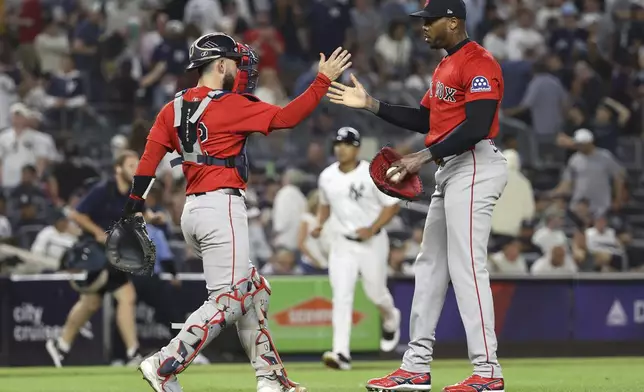 Boston Red Sox catcher Connor Wong, left, and pitcher Aroldis Chapman, right, react after defeating the New York Yankees during a baseball game Friday, Aug. 22, 2025, in New York. (AP Photo/Pamela Smith)