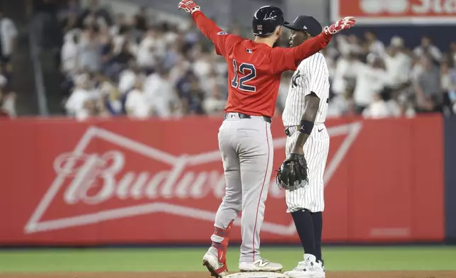 Boston Red Sox's Connor Wong, left, reacts next to New York Yankees second baseman Jazz Chisholm Jr., right, after hitting a double, leading Nathaniel Lowe to score, during the seventh inning of a baseball game Friday, Aug. 22, 2025, in New York. (AP Photo/Pamela Smith)