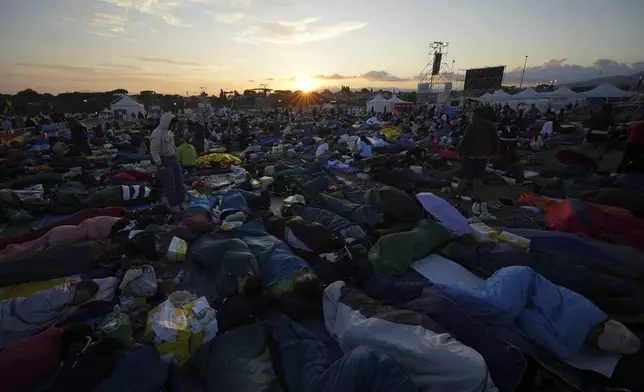 Young people wake up after spending the night at the Tor Vergata field in Rome as they participate in the Youths Jubilee, Sunday, Aug. 3, 2025. (AP Photo/Andrew Medichini)