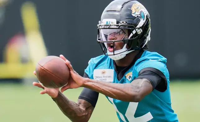 FILE - Jacksonville Jaguars wide receiver Travis Hunter makes a reception during the NFL football team's rookie minicamp, Saturday, May 10, 2025, in Jacksonville, Fla. (AP Photo/John Raoux, File)