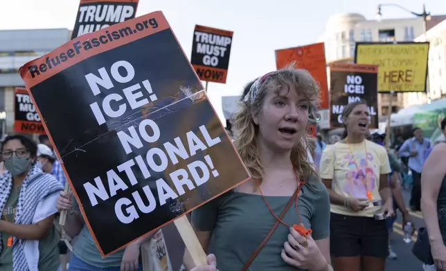 People protest against President Donald Trump's use of federal law enforcement and National Guard troops in the city during a march in downtown Columbia Heights neighborhood in Washington, Friday, Aug. 22, 2025. (AP Photo/Jose Luis Magana)