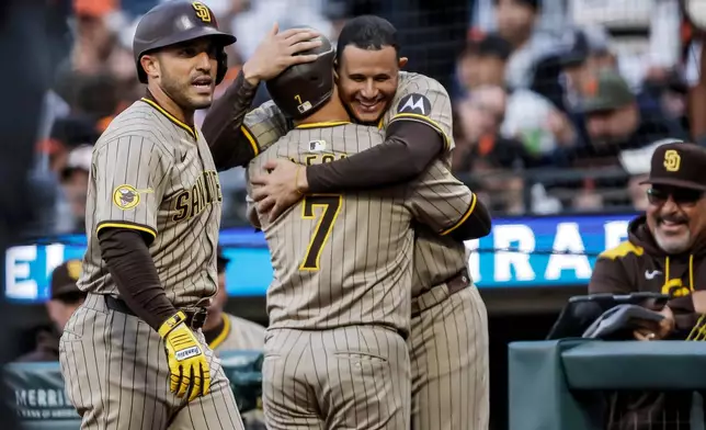 San Diego Padres' Manny Machado hugs teammate Jose Iglesias (7) after he hit a two-run homerun in the second inning of a baseball game against the San Francisco Giants at Oracle Park in San Francisco, on Tuesday, Aug. 12, 2025. (Carlos Avila Gonzalez/San Francisco Chronicle via AP)