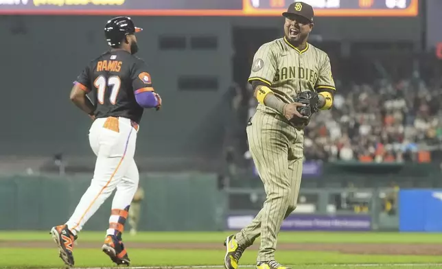 San Diego Padres first baseman Luis Arraez, right, reacts after catching a pop out hit by San Francisco Giants' Heliot Ramos (17) during the sixth inning of a baseball game in San Francisco, Tuesday, Aug. 12, 2025. (AP Photo/Jeff Chiu)
