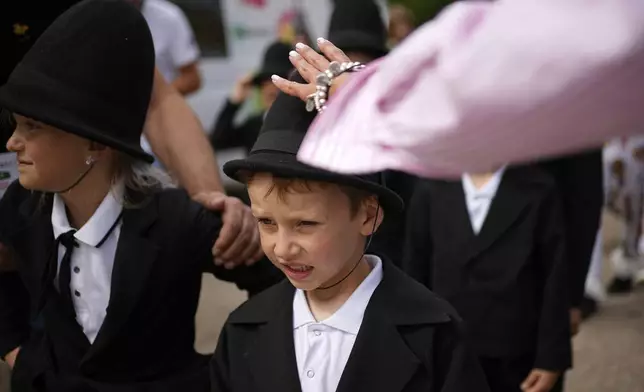 Young actors prepare for Karandash-Fest, a street festival of ciscus performers in Staritsa, Tver region, Russia, Saturday, Aug. 2, 2025. (AP Photo/Pavel Bednyakov)