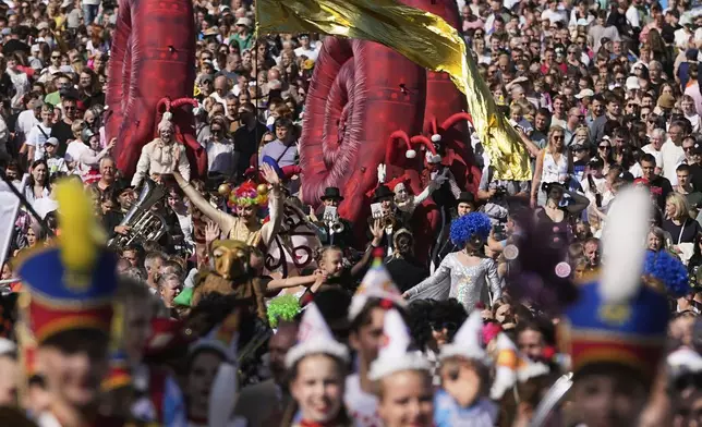 Circus performers march along a bridge over Volga river during Karandash-Fest, a street festival of ciscus performers in Staritsa, Tver region, Russia, Saturday, Aug. 2, 2025. (AP Photo/Pavel Bednyakov)
