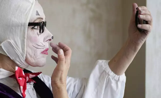 A circus artist prepares for Karandash-Fest, a street festival of ciscus performers in Staritsa, Tver region, Russia, Saturday, Aug. 2, 2025. (AP Photo/Pavel Bednyakov)