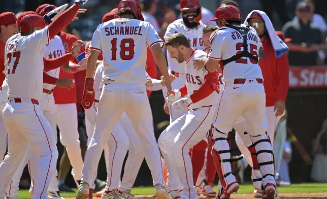 Los Angeles Angels' Taylor Ward, center right, celebrates at home plate after hitting a three-run walkoff home run during the ninth inning of a baseball game against the Chicago White Sox, Sunday, Aug. 3, 2025, in Anaheim, Calif. (AP Photo/Jayne Kamin-Oncea)