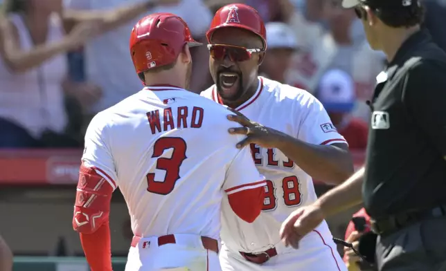 Los Angeles Angels' Taylor Ward (3) celebrates with third base coach Bo Porter, center, as he rounds the bases after hitting a three-run walkoff home run during the ninth inning of a baseball game against the Chicago White Sox, Sunday, Aug. 3, 2025, in Anaheim, Calif. (AP Photo/Jayne Kamin-Oncea)