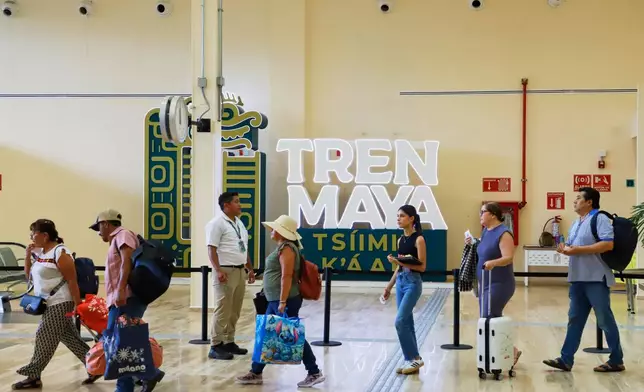 Passengers pass through a hallway to board the Maya Train in Mérida, Mexico, Thursday, Aug. 14, 2025. (AP Photo/Martin Zetina)