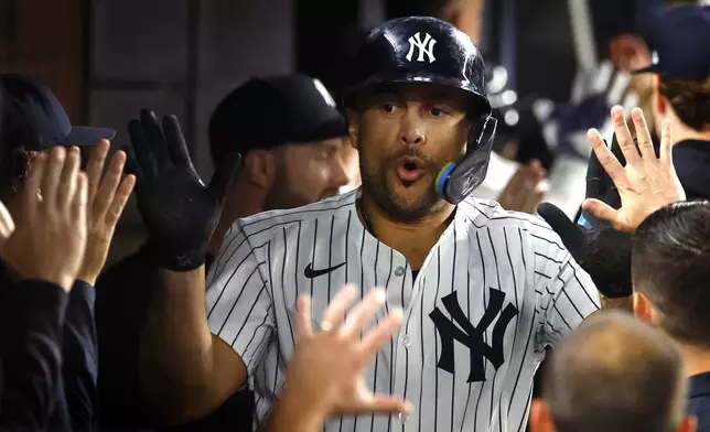 New York Yankees' Giancarlo Stanton celebrates with teammates after hitting a two run home run during the sixth inning of a baseball game against the Washington Nationals, Tuesday, Aug. 26, 2025, in New York. (AP Photo/Noah K. Murray)