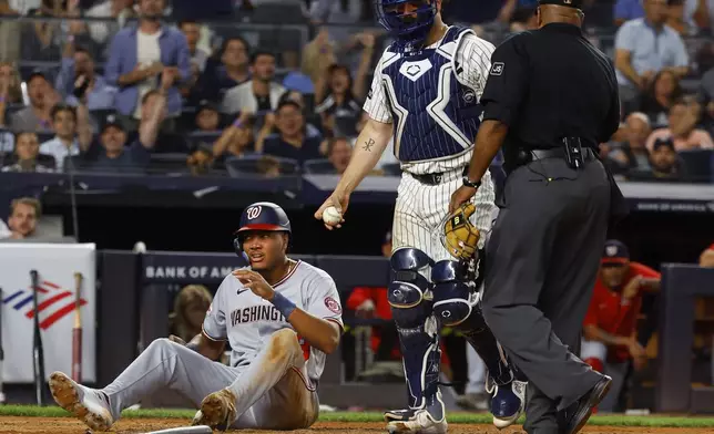 Washington Nationals' James Wood reacts after being tagged out by New York Yankees catcher Austin Wells during the fifth inning of a baseball game, Tuesday, Aug. 26, 2025, in New York. (AP Photo/Noah K. Murray)