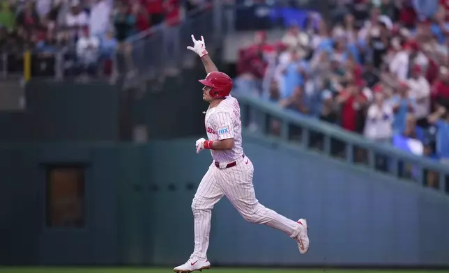 Philadelphia Phillies' J.T. Realmuto reacts after hitting a home run against Seattle Mariners pitcher Logan Gilbert during the second inning of a baseball game Monday, Aug. 18, 2025, in Philadelphia. (AP Photo/Matt Slocum)