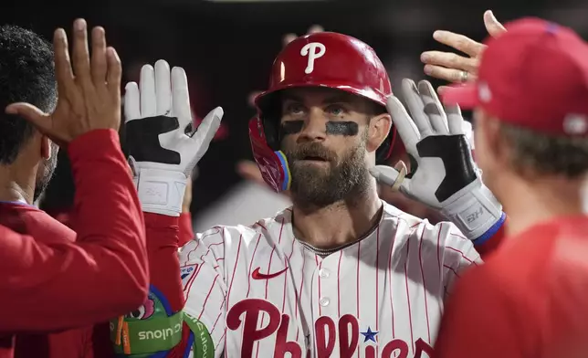 Philadelphia Phillies' Bryce Harper celebrates with teammates after hitting a two-run home run against Seattle Mariners pitcher Casey Legumina during the seventh inning of a baseball game Monday, Aug. 18, 2025, in Philadelphia. (AP Photo/Matt Slocum)