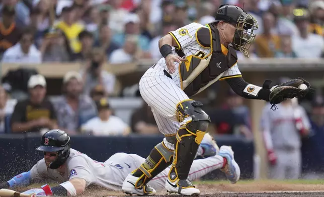 Boston Red Sox's Trevor Story scores from third base off a fielder's choice by Masataka Yoshida as San Diego Padres catcher Freddy Fermin bobbles the ball during the third inning of a baseball game Saturday, Aug. 9, 2025, in San Diego. (AP Photo/Gregory Bull)