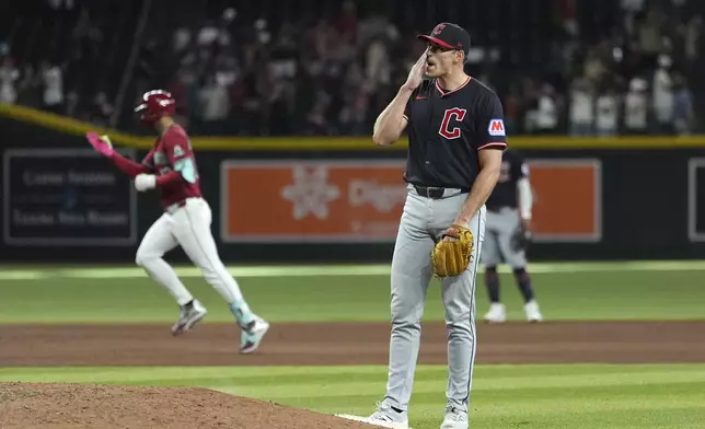 Cleveland Guardians pitcher Cade Smith, right, pauses behind the pitcher's mound after giving up a home run to Arizona Diamondbacks' Lourdes Gurriel Jr., left, during the ninth inning of a baseball game Wednesday, Aug. 20, 2025, in Phoenix. (AP Photo/Ross D. Franklin)