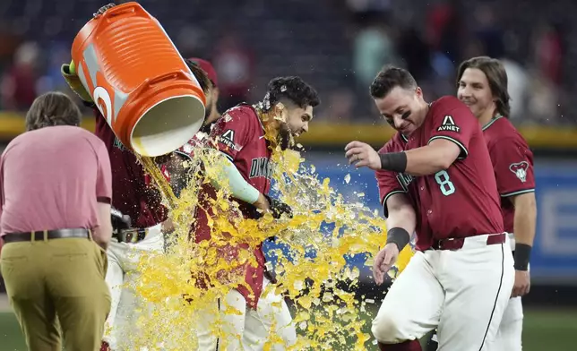Arizona Diamondbacks' Adrian Del Castillo, left, gets hit with Gatorade as he celebrates his walk-off single against the Cleveland Guardians with Diamondbacks' James McCann (8) after a baseball game Wednesday, Aug. 20, 2025, in Phoenix. (AP Photo/Ross D. Franklin)