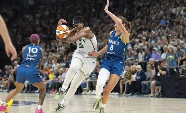 New York Liberty center Jonquel Jones (35) loses control of the ball as she attempts to drive between Minnesota Lynx guard Courtney Williams (10) and Minnesota Lynx forward Alanna Smith (8) in the fourth quarter of a WNBA basketball game Saturday, Aug. 16, 2025, in Minneapolis. (Alex Kormann/Star Tribune via AP)