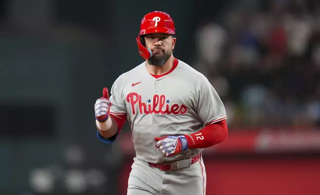 Philadelphia Phillies designated hitter Kyle Schwarber gestures while running the bases after hitting a solo home run off Texas Rangers pitcher Merrill Kelly during the first inning of a baseball game Friday, Aug. 8, 2025, in Arlington, Texas. (AP Photo/Julio Cortez)