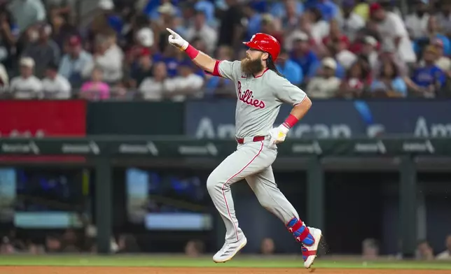 Philadelphia Phillies' Brandon Marsh reacts while running the bases after hitting a solo home run off Texas Rangers pitcher Merrill Kelly during the fourth inning of a baseball game Friday, Aug. 8, 2025, in Arlington, Texas. (AP Photo/Julio Cortez)