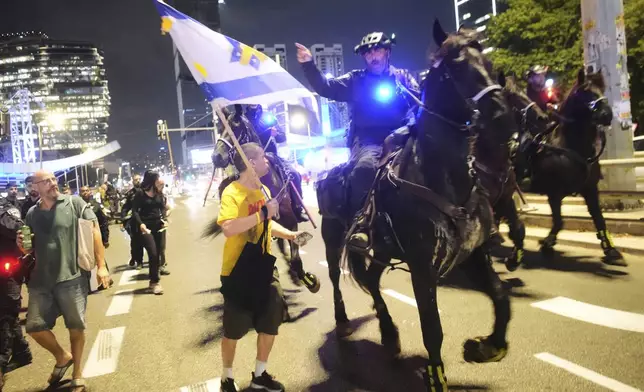 Mounted police disperse demonstrators blocking a highway during a protest demanding the release of all hostages held by Hamas in the Gaza Strip and calling for an end to the war, in Tel Aviv, Israel, Saturday, Aug. 9, 2025. (AP Photo/Ohad Zwigenberg)
