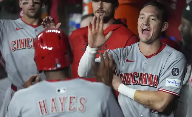 Cincinnati Reds' Ke'Bryan Hayes, left, celebrates his run scored against the Arizona Diamondbacks with Reds' Austin Hays, right, during the second inning of a baseball game Friday, Aug. 22, 2025, in Phoenix. (AP Photo/Ross D. Franklin)