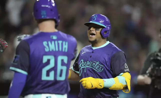 Arizona Diamondbacks' Gabriel Moreno, right, celebrates his three-run home run against the Cincinnati Reds with Diamondbacks' Pavin Smith (26) during the third inning of a baseball game Friday, Aug. 22, 2025, in Phoenix. (AP Photo/Ross D. Franklin)