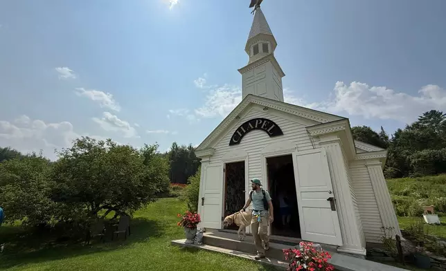 Billy Curtin and his dog, Brewster, leave the Dog Chapel at Dog Mountain, a 150-acre dog park created by Vermont folk artist Stephen Huneck, Thursday, Aug. 7, 2025, in St. Johnsbury, Vt. (AP Photo/Amanda Swinhart)