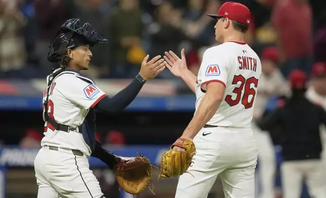 Cleveland Guardians catcher Bo Naylor, left, and relief pitcher Cade Smith (36) shake hands after the Guardians defeated the Tampa Bay Rays in a baseball game in Cleveland, Tuesday, Aug. 26, 2025. (AP Photo/Sue Ogrocki)