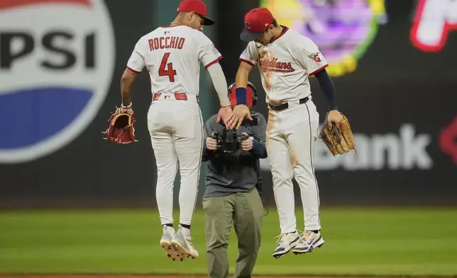 Cleveland Guardians second baseman Brayan Rocchio (4) and left fielder Steven Kwan, right, celebrate after the Guardians defeated the Tampa Bay Rays in a baseball game in Cleveland, Tuesday, Aug. 26, 2025. (AP Photo/Sue Ogrocki)