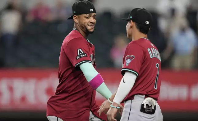 Arizona Diamondbacks' Ketel Marte and Jorge Barrosa, right, celebrate the team's win in a baseball game against the Texas Rangers Wednesday, Aug. 13, 2025, in Arlington, Texas. (AP Photo/Tony Gutierrez)