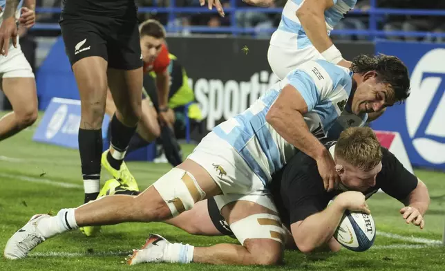 New Zealand's All Blacks Fletcher Newell scores a try as he is tackled by Argentina's Los Pumas Pablo Matera during a rugby championship match in Buenos Aires, Argentina, Saturday, Aug. 23, 2025. (AP Photo/Gustavo Garello)