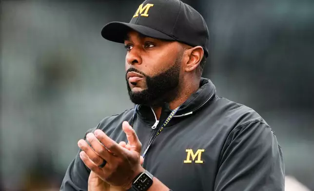 FILE - Michigan head coach Sherrone Moore walks on the field before an NCAA college football game against Washington, Saturday, Oct. 5, 2024, in Seattle. (AP Photo/Lindsey Wasson)