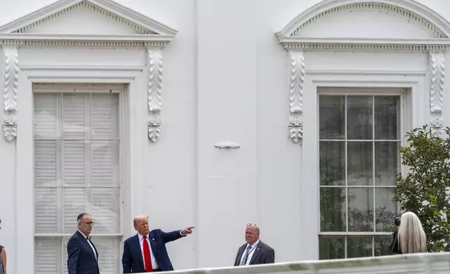 President Donald Trump, second from left, with architect James McCrery, left, surveys the grounds from the roof above the Colonnade that goes to the West Wing of the White House, Tuesday, Aug. 5, 2025, in Washington. (AP Photo/Alex Brandon)
