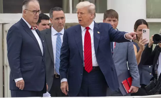 President Donald Trump, center, with architect James McCrery, left, surveys the grounds from the roof above the Colonnade that goes to the West Wing of the White House, Tuesday, Aug. 5, 2025, in Washington. (AP Photo/Alex Brandon)