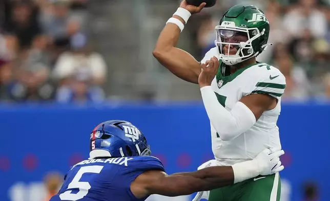 New York Jets quarterback Justin Fields (7) throws under pressure from New York Giants linebacker Kayvon Thibodeaux (5) during the first quarter of an NFL football game, Saturday, Aug. 16, 2025, in East Rutherford, N.J. (AP Photo/Yuki Iwamura)