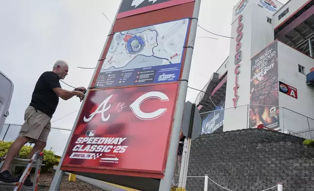 Rod Bruchell installs signs outside Bristol Motor Speedway, Friday, Aug. 1, 2025, in Bristol, Tenn., the day before the MLB Speedway Classic baseball game between the Cincinnati Reds and Atlanta Braves. (AP Photo/George Walker IV)