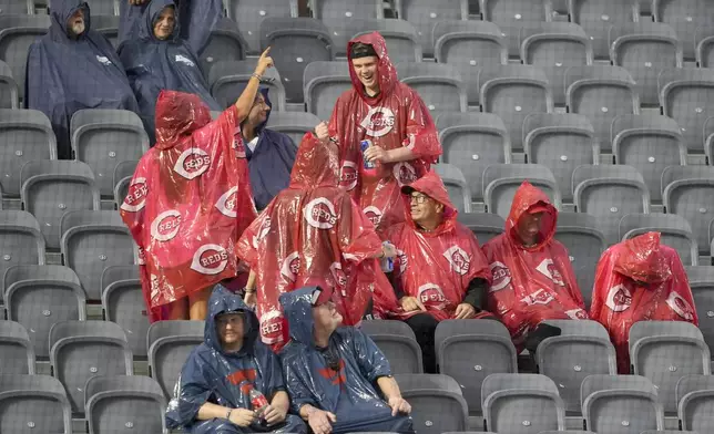 Fans wait in the rain for the delayed start of the MLB Speedway Classic baseball game between the Atlanta Braves and the Cincinnati Reds at Bristol Motor Speedway in Bristol, Tenn., Saturday, Aug. 2, 2025. (AP Photo/Chris Carlson)